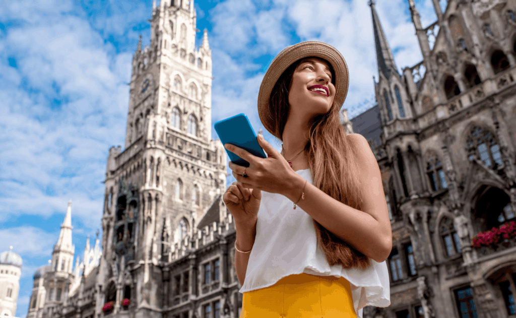 A female traveller in a city smiling with a smartphone - megatrends tourism 2026