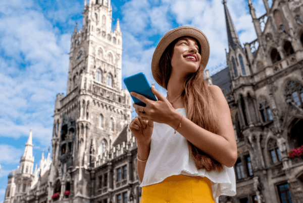 A female traveller in a city smiling with a smartphone - megatrends tourism 2026