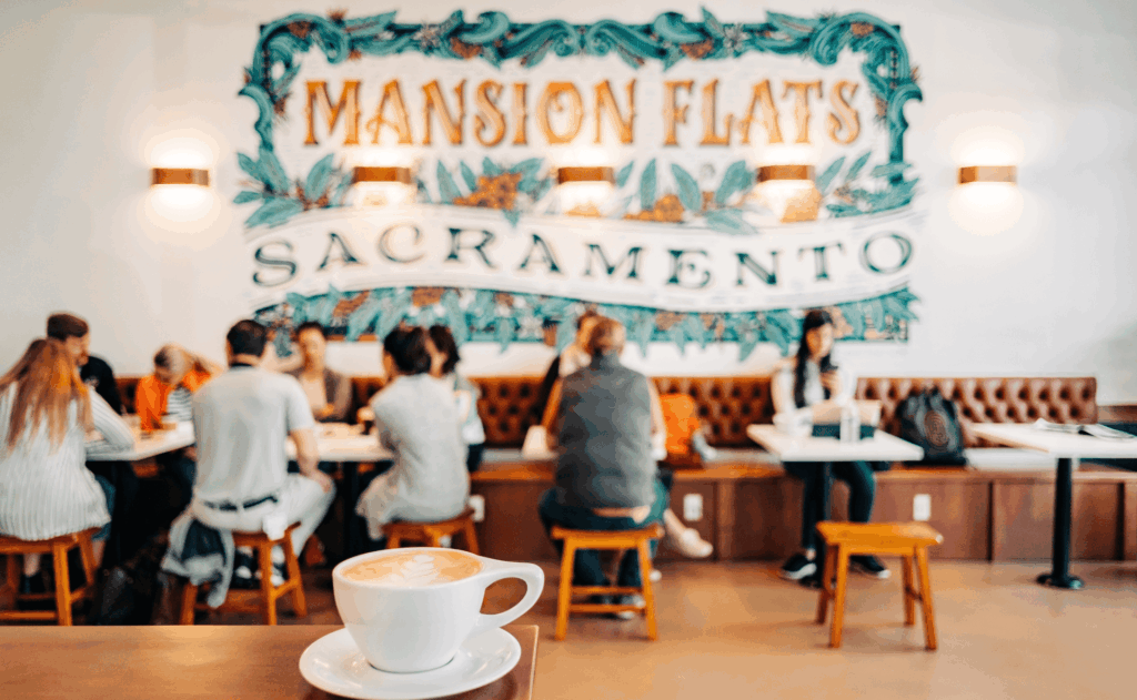 a cafe in sacramento with people seated around a table and a coffee cup in a corner