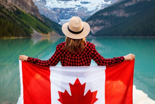 a Canadian traveller in front of a lake with the Canada flag