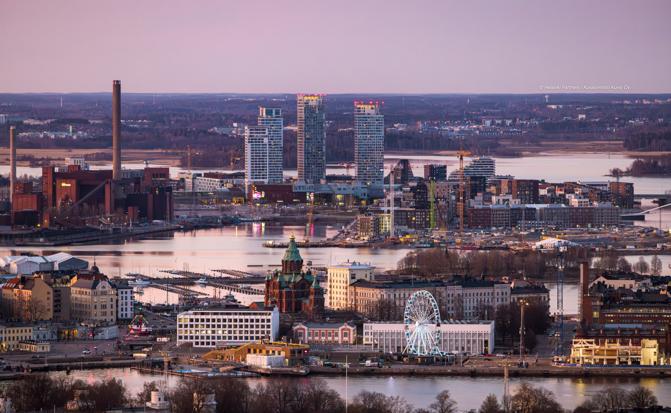 a panoramic view of Helsinki bathed in the warm golden light of sunset